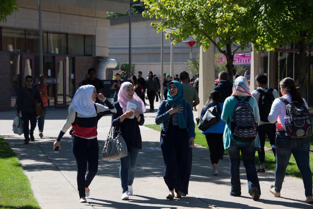 Students walking across campus on a sunny day
