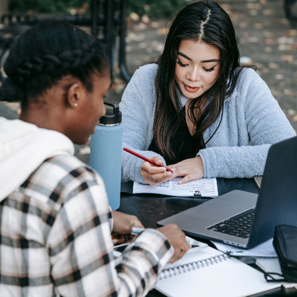 two students working on a laptop