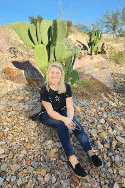 Beata sitting in front of a cactus