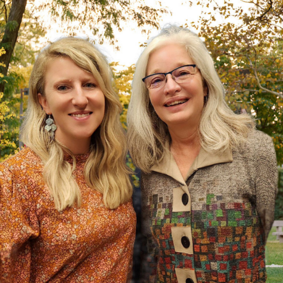 Advisors Beata and Debbie standing outside on the UIC campus with fall trees in the background
